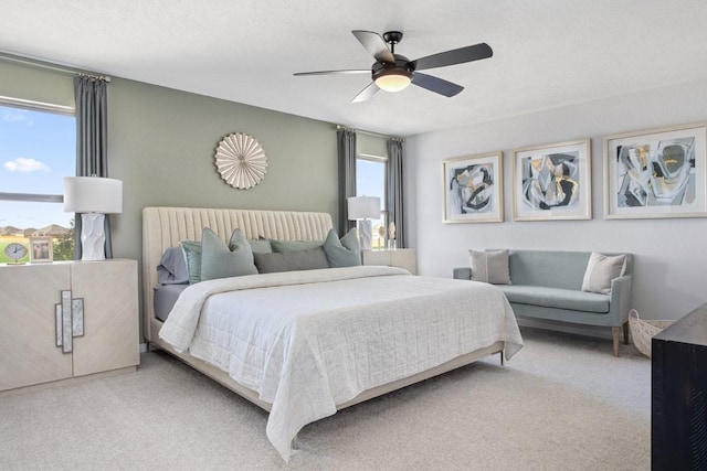 carpeted bedroom with ceiling fan and a textured ceiling