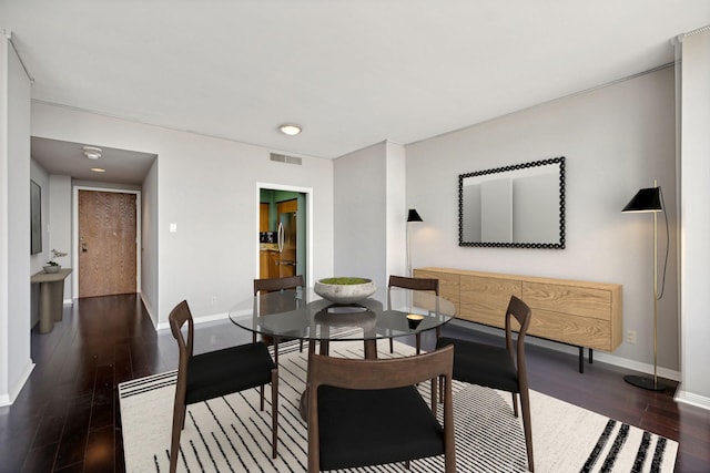 dining space featuring dark wood-type flooring