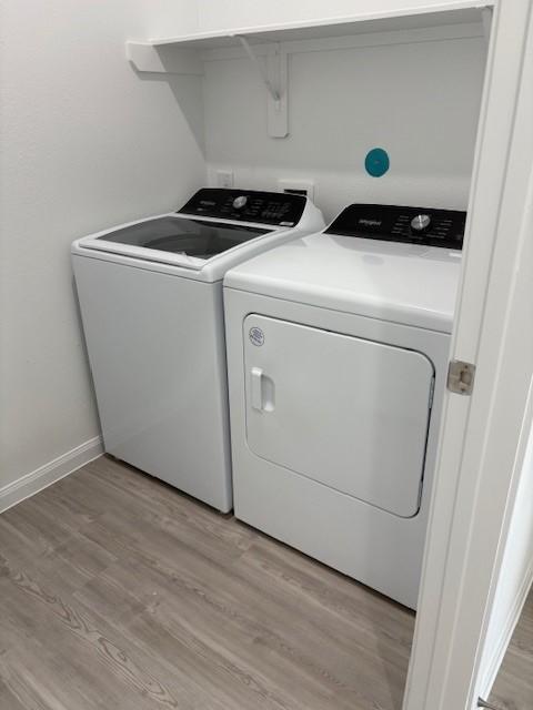 23506 Daisy Grubber Ln, Hockley, TX 77447 - laundry room featuring washer and dryer, light wood finished floors, and baseboards