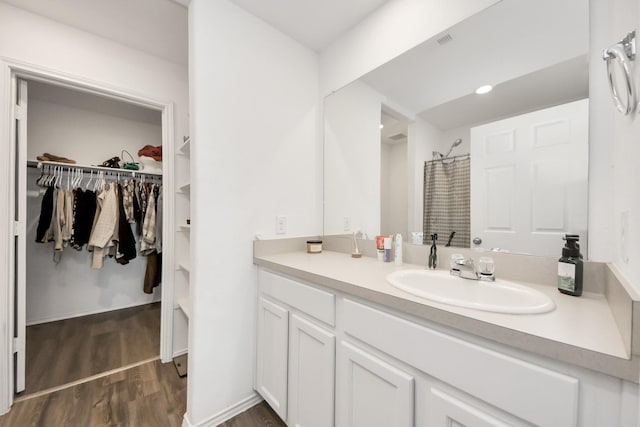 bathroom featuring wood-type flooring, a shower with shower curtain, and vanity