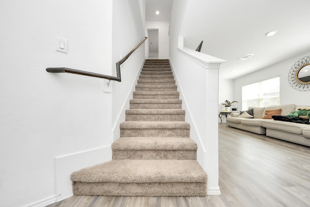 staircase with hardwood / wood-style floors