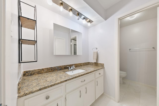 bathroom with vanity, tile patterned floors, and toilet