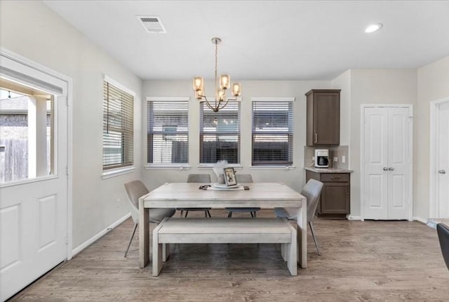 dining room with an inviting chandelier and light hardwood / wood-style flooring