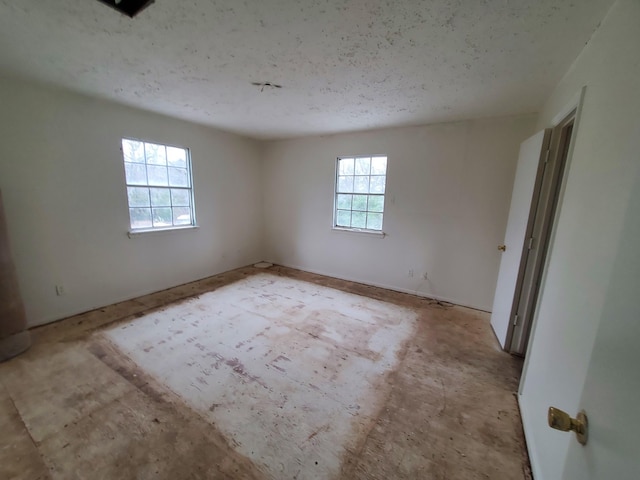 spare room featuring plenty of natural light and a textured ceiling