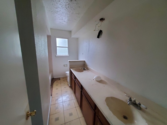 bathroom featuring vanity, toilet, and a textured ceiling