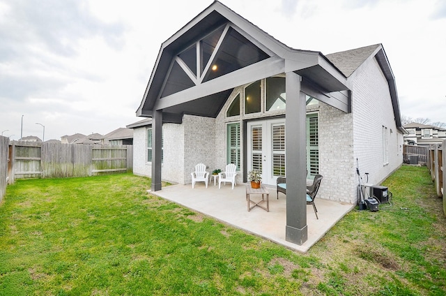 rear view of house with a patio and a lawn