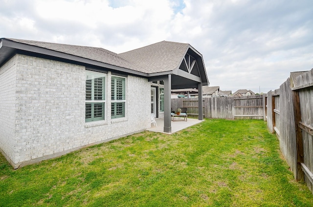 back of property with a yard and a patio