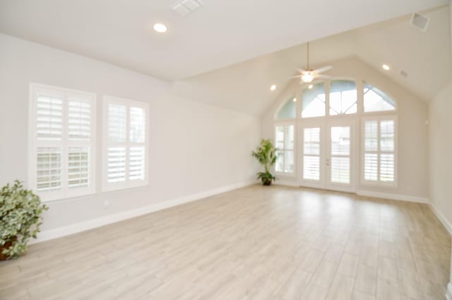 empty room with french doors, ceiling fan, high vaulted ceiling, and light hardwood / wood-style flooring