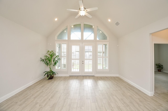 empty room featuring plenty of natural light, lofted ceiling, ceiling fan, and light hardwood / wood-style flooring