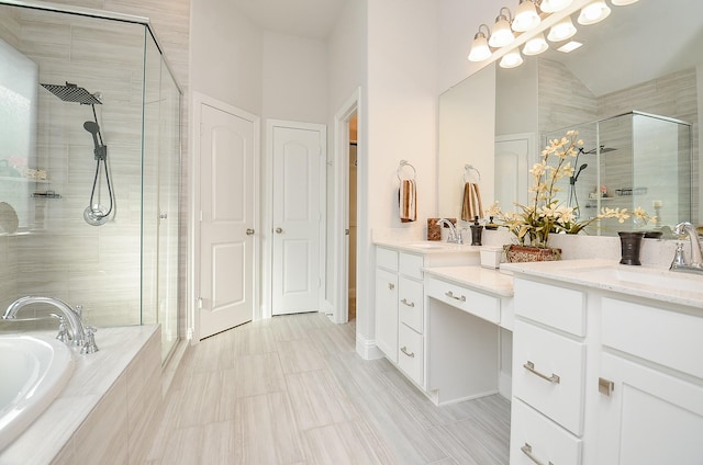 bathroom with vaulted ceiling, vanity, and separate shower and tub