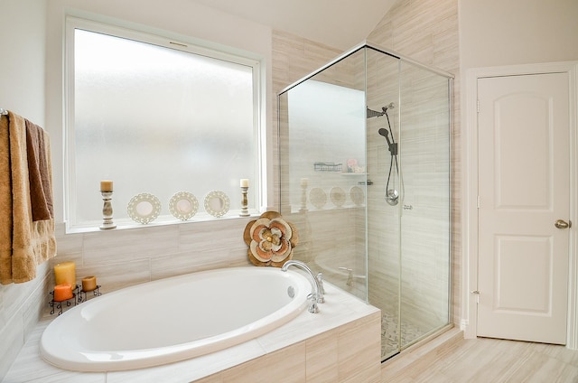 bathroom featuring shower with separate bathtub