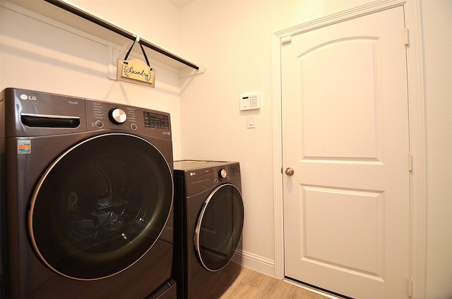 laundry area featuring washer and dryer and light wood-type flooring