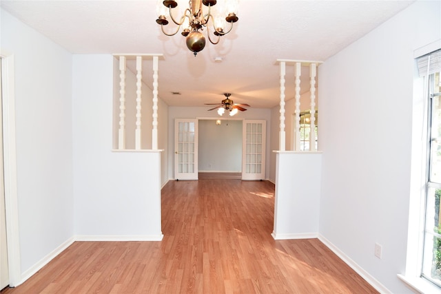 interior space featuring ceiling fan with notable chandelier, a healthy amount of sunlight, and light hardwood / wood-style floors