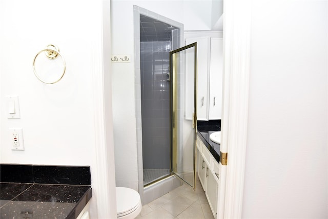 bathroom with tile patterned flooring, vanity, a shower with door, and toilet