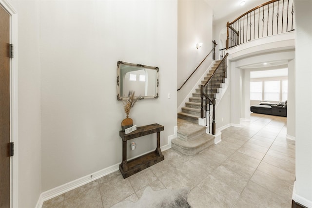 entrance foyer featuring light tile patterned flooring and a high ceiling