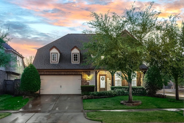 view of front of property with a garage and a lawn