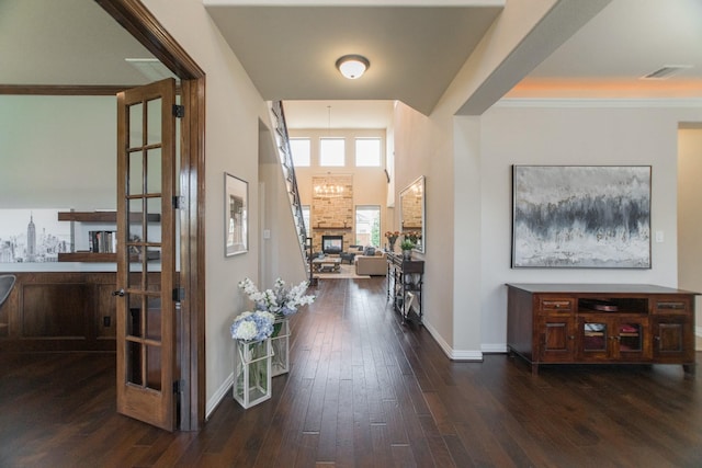 entrance foyer featuring dark hardwood / wood-style flooring and a large fireplace