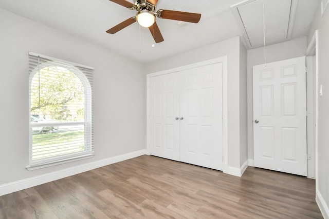 unfurnished bedroom with ceiling fan, wood-type flooring, and a closet