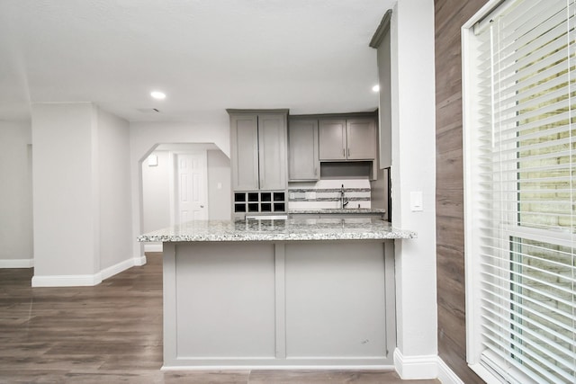 kitchen with gray cabinets, light stone countertops, dark hardwood / wood-style floors, and sink