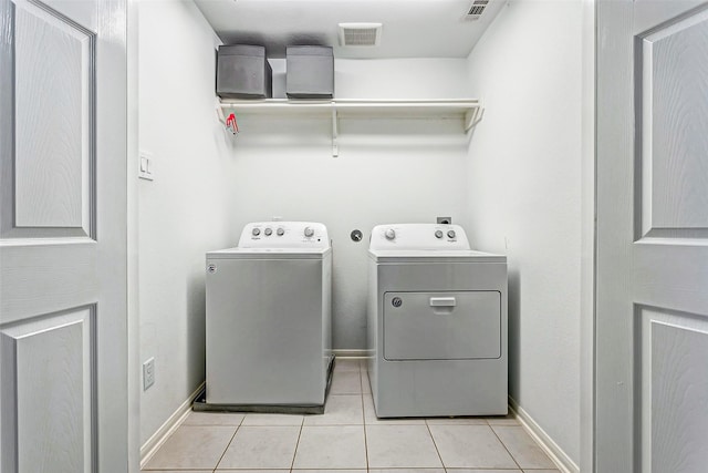 laundry area featuring washer and dryer and light tile patterned flooring