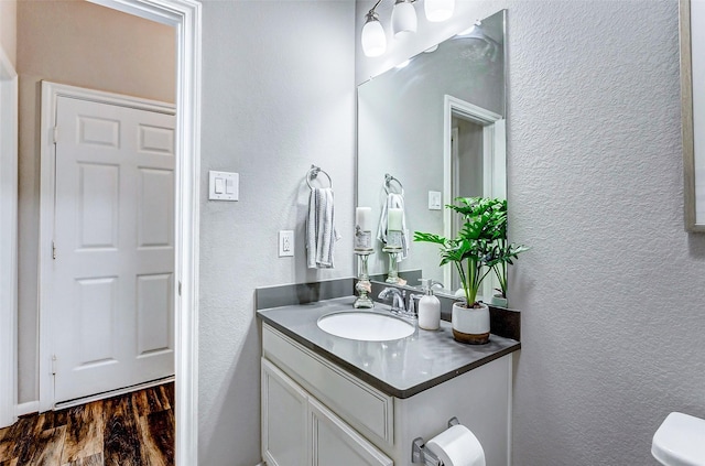 bathroom featuring hardwood / wood-style flooring, vanity, and toilet