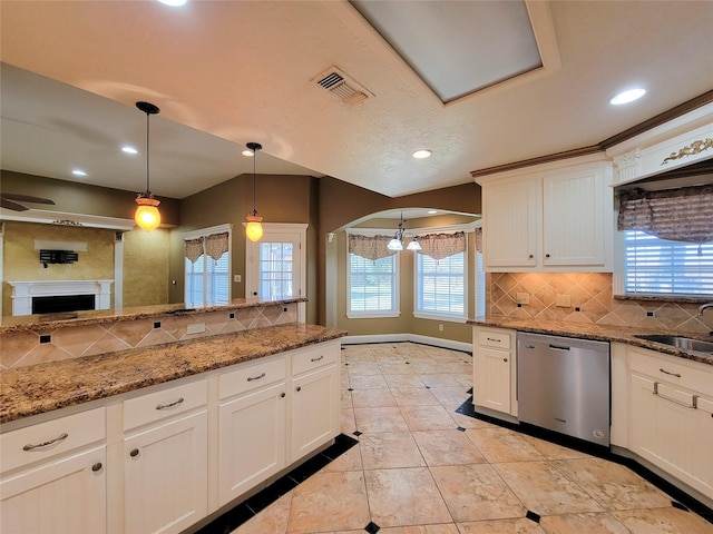 kitchen featuring sink, white cabinetry, hanging light fixtures, dark stone countertops, and dishwasher