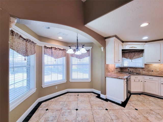 kitchen with white cabinetry, decorative light fixtures, light tile patterned flooring, and backsplash