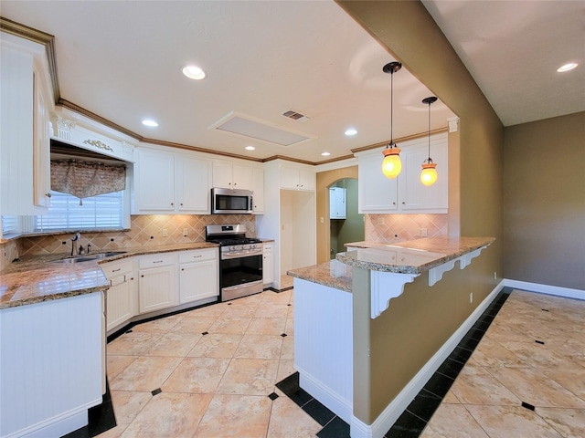 kitchen featuring stainless steel appliances, pendant lighting, white cabinets, and kitchen peninsula