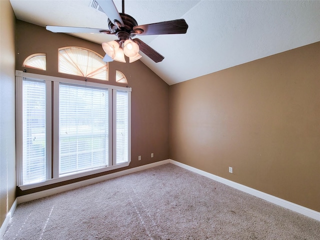 empty room with vaulted ceiling, ceiling fan, and carpet