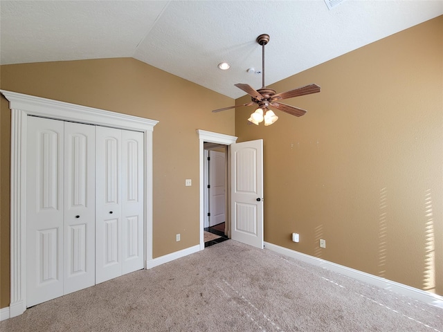 unfurnished bedroom featuring ceiling fan, lofted ceiling, carpet floors, and a closet