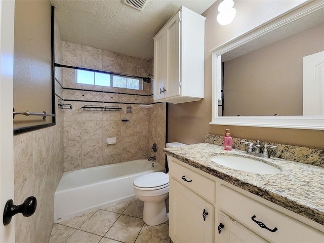 full bathroom with tiled shower / bath, vanity, toilet, tile patterned floors, and a textured ceiling