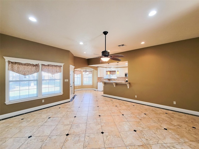 unfurnished living room with ceiling fan and light tile patterned flooring