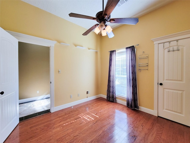 unfurnished bedroom with ceiling fan and hardwood / wood-style floors