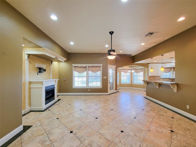 unfurnished living room with light tile patterned flooring and ceiling fan