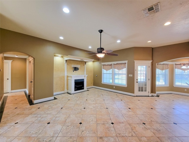 unfurnished living room with ceiling fan, lofted ceiling, and light tile patterned floors