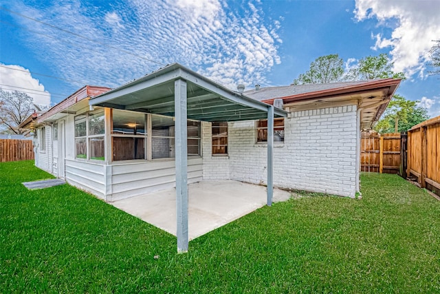 rear view of house featuring a lawn and a patio area