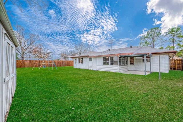 back of house with a lawn, a patio, and a playground