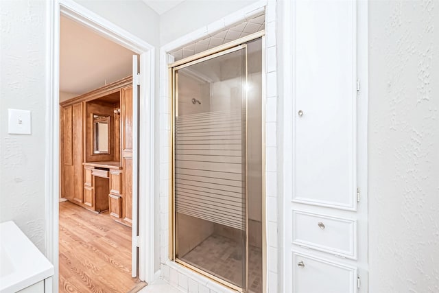 bathroom with an enclosed shower and wood-type flooring