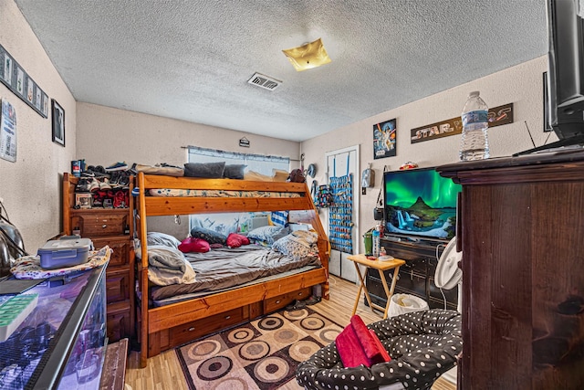 bedroom with hardwood / wood-style floors and a textured ceiling