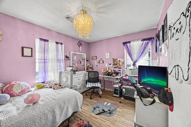 bedroom featuring hardwood / wood-style floors and a textured ceiling