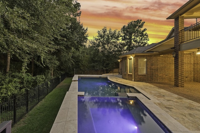 pool at dusk with a patio