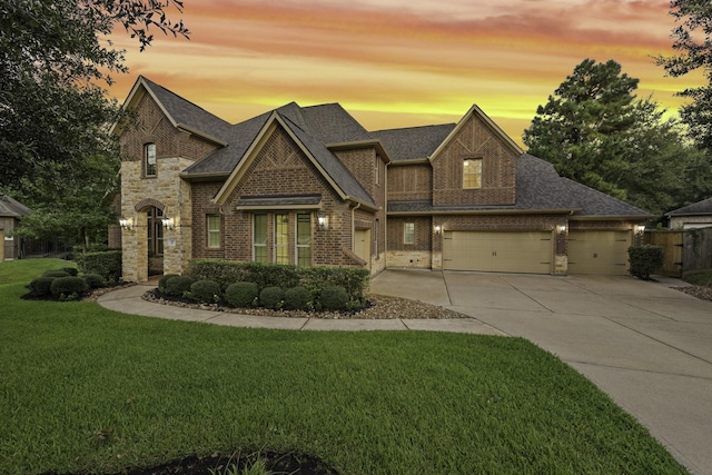 view of front of house featuring a garage and a lawn