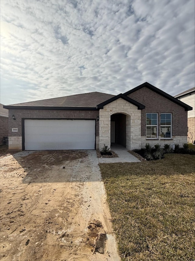 view of front of property featuring a garage and a front lawn