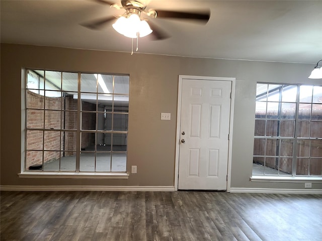 foyer entrance featuring dark wood-type flooring, ceiling fan, and a healthy amount of sunlight