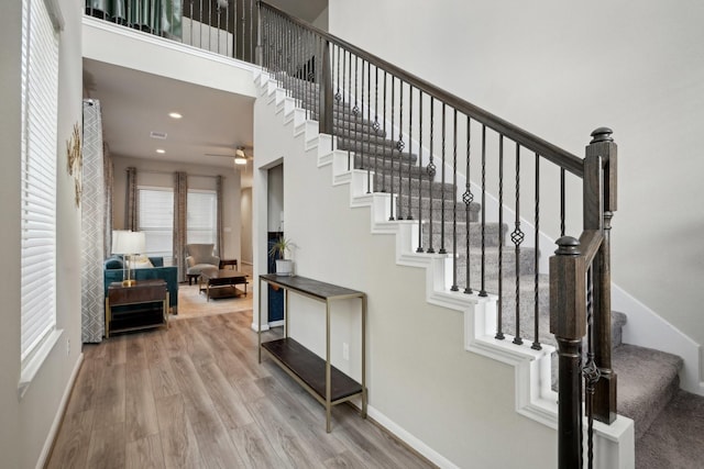 staircase featuring hardwood / wood-style flooring and a high ceiling