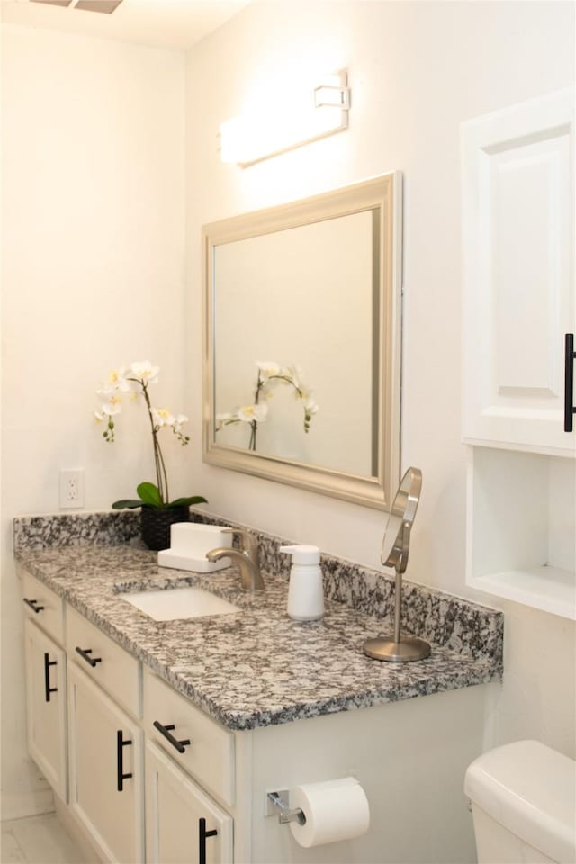 bathroom featuring vanity and toilet