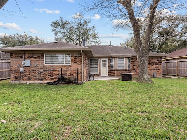 rear view of house with a yard and a patio