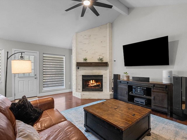 living room featuring hardwood / wood-style floors, a fireplace, vaulted ceiling with beams, and ceiling fan