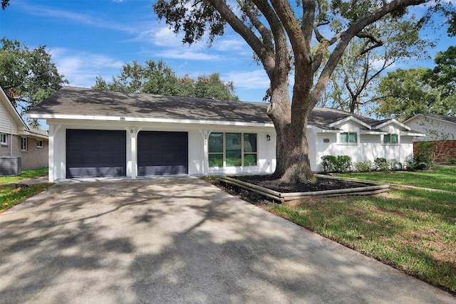 single story home featuring a garage, a front yard, and central AC unit