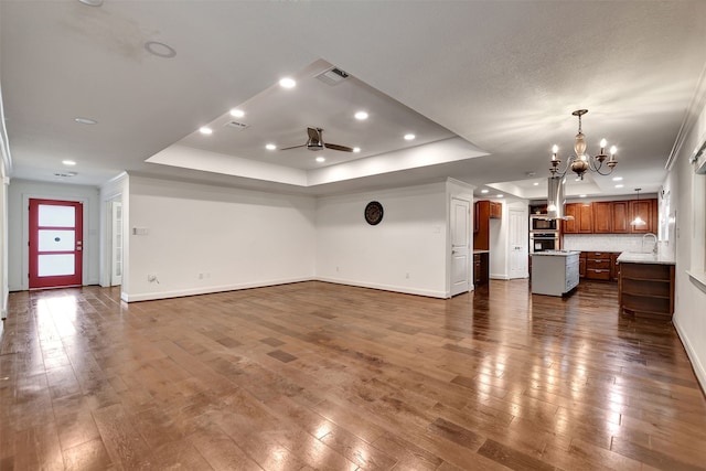 unfurnished living room with dark hardwood / wood-style flooring and a tray ceiling